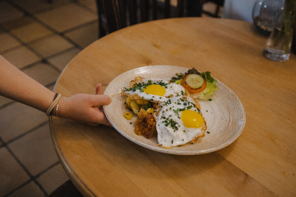 Eine Bedienung serviert Bratkartoffeln mit Eiern im Stechlkeller
