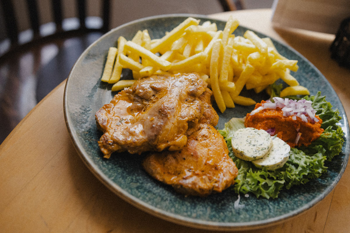 ein deftiges Steak mit Pommes und Beilagen serviert im Stechl Keller in Wasserbrug am Inn